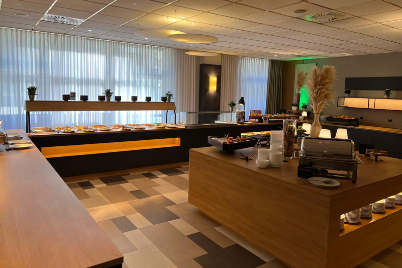 Restaurant area at the NOVINA Hotel am Südwestpark Nuremberg with food serving and dessert area without guests.