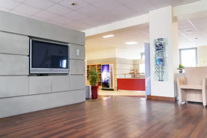 qSkills Lounge mit Monitor und Zeitschriftenständer