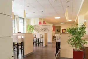 Blick in den Cafe & Lounge Bereich sowie Garderobe und Eingangszone von qSkills, ohne Teilnehmende