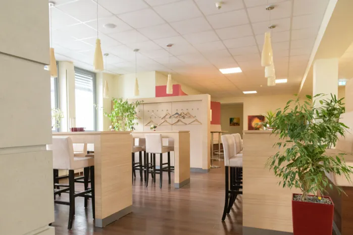 Blick in den Cafe & Lounge Bereich sowie Garderobe und Eingangszone von qSkills, ohne Teilnehmende