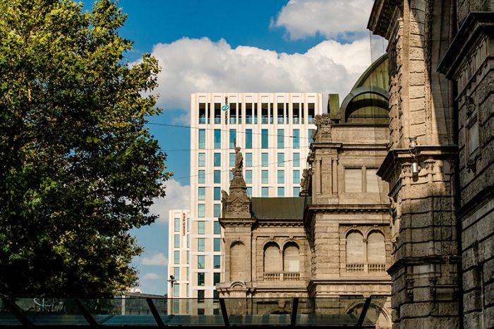 Exterior view of Hotel Motel One from the west side, including the listed facade of Nuremberg Central Station in the foreground.