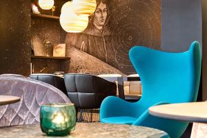 Close-up of the seating area with astrology-themed wall art and lamps in the constellation at the Motel One Nuremberg-Plärrer hotel.