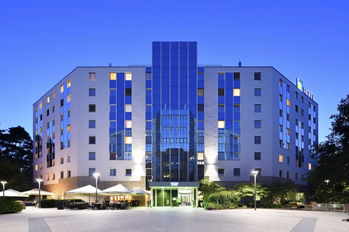 Novina Business Hotel at Südwestpark Nuremberg: Exterior view including main entrance, beer garden, and terrace at dusk.