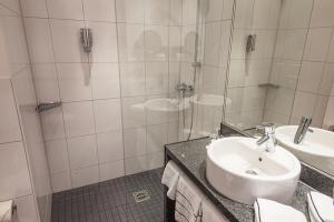 Novina Hotel Tillypark Nuremberg: View of standard bathroom with white tiles, glass shower, and sink